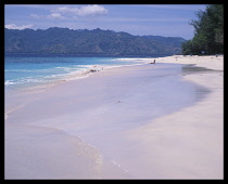 Indonesia, Lombok , The Gili Islands, Gili Meno, Empty beach View along shoreline to Lombok.