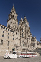 Spain, Galicia, Santiago de Compostela, the Cathedral of Santiago de Compostela with a tourist train in Plaza del Obradoiro.