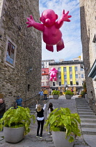 Canada, Quebec Province, Quebec City. Alley leading to Place Royale in Old Quebec City, Vieux Quebec in Basse-Ville or Lower Town. One of the inflatable Mr Pink, or Monsieur Rose S'Envole, sculptures...