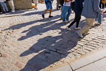 Canada, Quebec Province, Quebec City, Pedestrianswith long shadows walking towards Place Royale in Old Quebec City, Vieux Quebec in Basse-Ville or Lower Town.