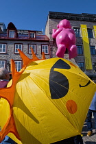 Canada, Quebec Province, Quebec City, Quebec Old City or Vieux Quebec, in Basse-Ville or Lower Town. Tourist with Smiley umbrella in Place Royale looking at one of the inflatable Mr Pink, or Monsieur...