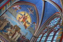 France, Paris, Cathedral de Notre Dame, Stained glass window and colourfu religious artwork in a chapel of the restored cathedral after the fire of 2019.