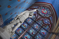 France, Paris, Cathedral de Notre Dame, Stained glass window with a statue of Saint George slaying the dragon in the restored cathedral after the fire of 2019.