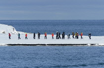 Norway, Svalbard, Magdalenfjorden. Tourists hike up narrow penninsula to an old whaling station.