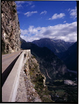France, Isere, Narrow mountain road in clinging to cliffside with view over Romanche valley below.