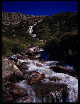 France, Isere, Stream du Lac Grand Lac flowing down rocky mountainside from Le Grand Lac to Lac de Grand Maison.