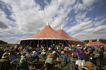 England, Hampshire, Eastleigh, Wickham Festival, Revellers sat on camping chairs listening to band.