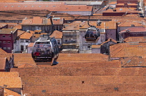 Portugal, Porto, Vila Nova de Gaia, The Teleférico de Gaia aerial gondola in motion high above the rooftops.