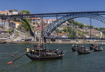 Portugal, Porto, Dom Luis I Bridge or Ponte de Dom Luis I, Double-deck metal arch bridge over the Rver Douro which was opened in 1886, Rabelo cargo boats on the River Douro in the foreground that were...