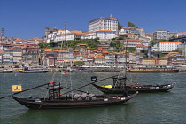 Portugal, Porto, Vila Nova de Gaia, Rabelo cargo boats on the River Douro with the Ribeira area of Porto in the background, Rabelo cargo boats were used for bringing wine from the vineyards in the Dou...