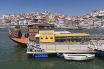 Portugal, Porto, Vila Nova de Gaia, Decorated tourist boats moored at a jetty with Sandeman sign, and the Ribeira area of Porto in the background.